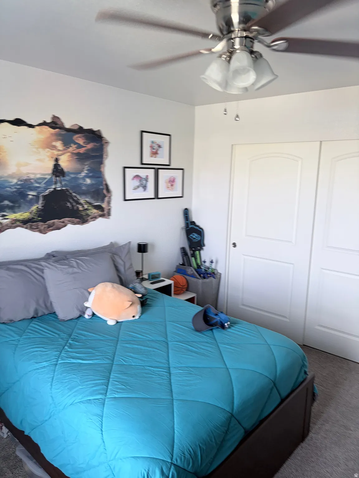 Bedroom featuring a ceiling fan with integrated lighting, two-panel closet doors, and light-colored carpeting