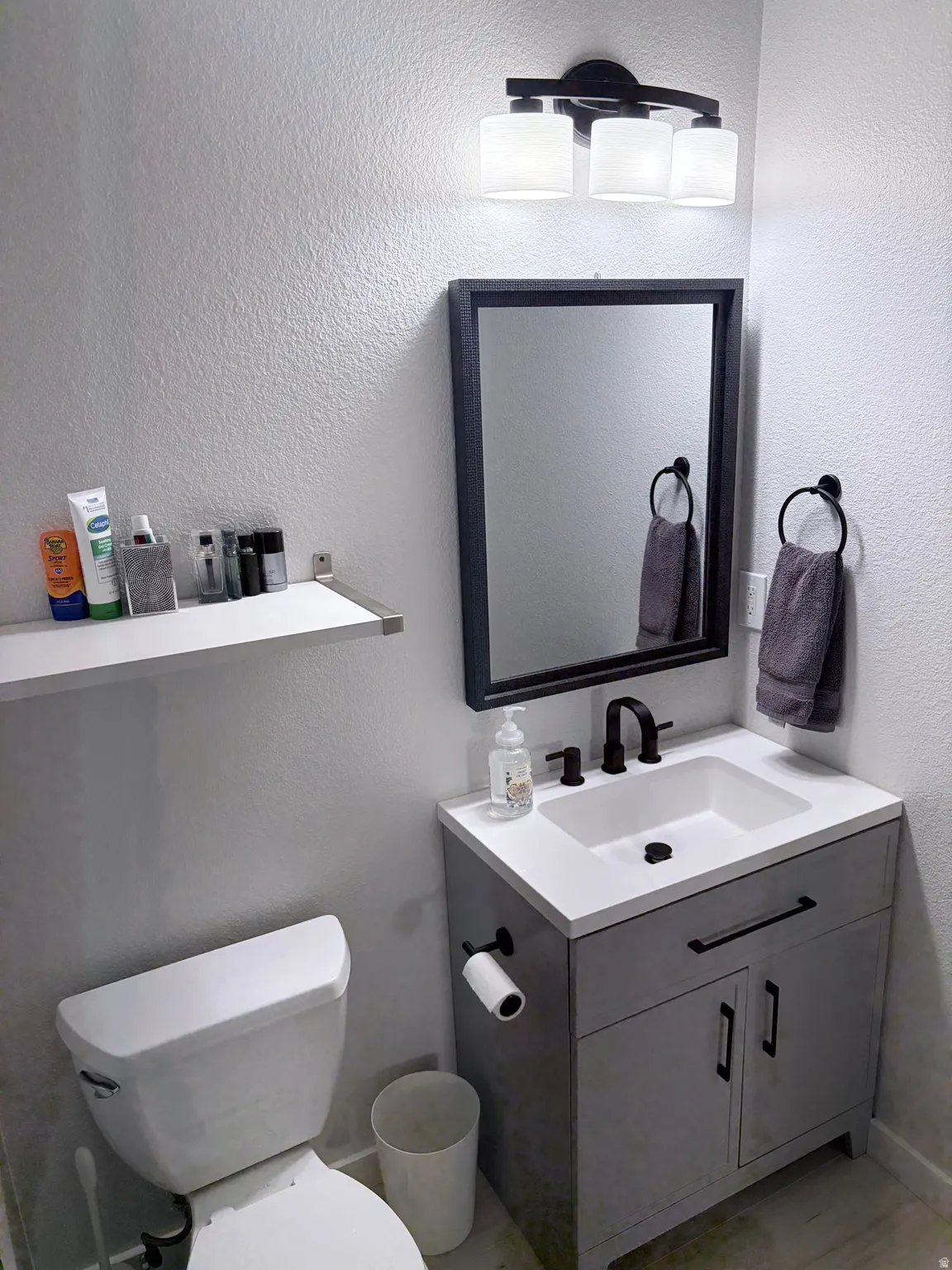 Modern bathroom featuring a contemporary vanity with an integrated sink, matte black faucet, and a coordinating framed mirror