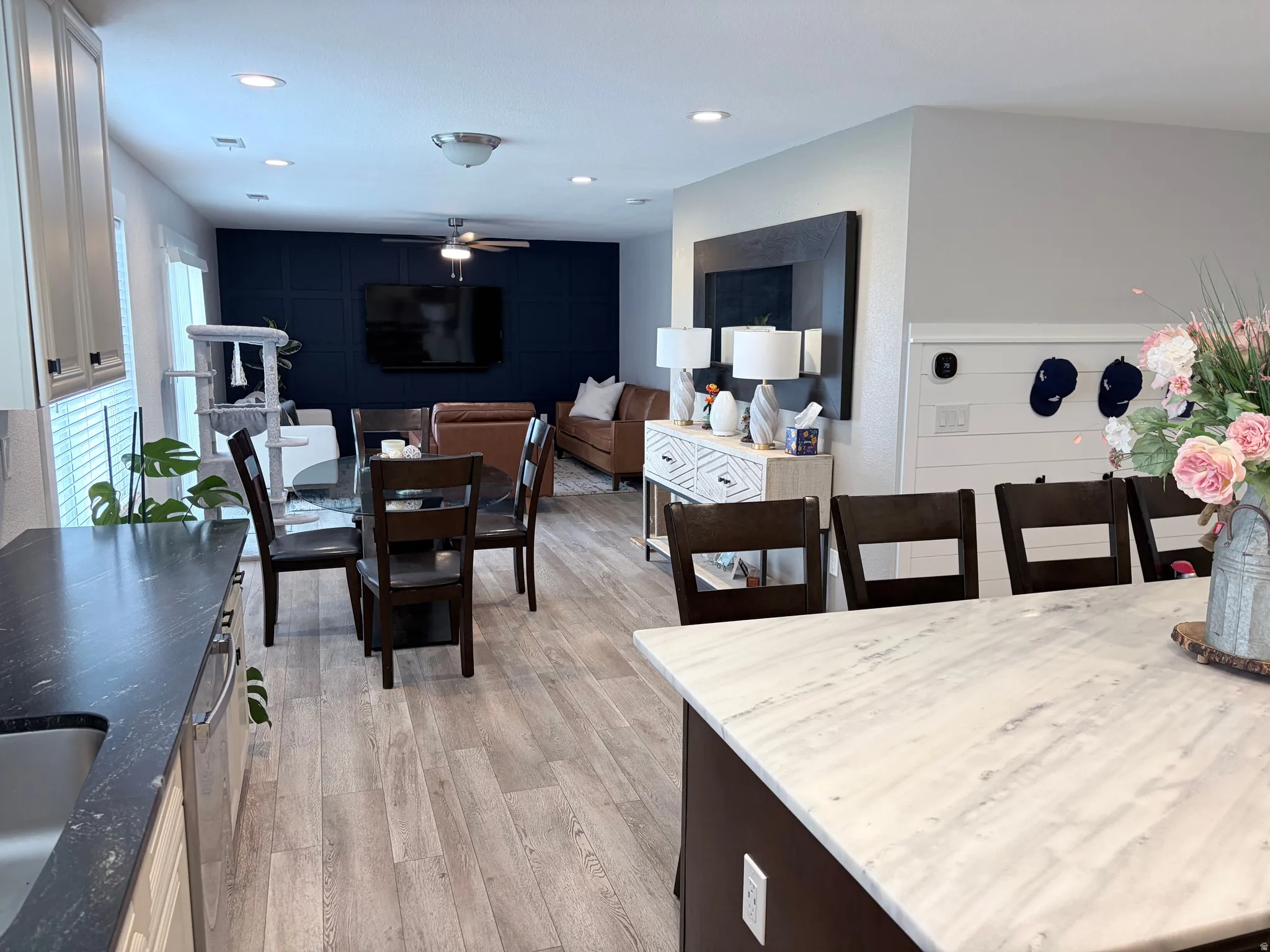 Open-concept living space featuring wood-finish flooring, recessed lighting, and a kitchen island with a light-toned countertop
