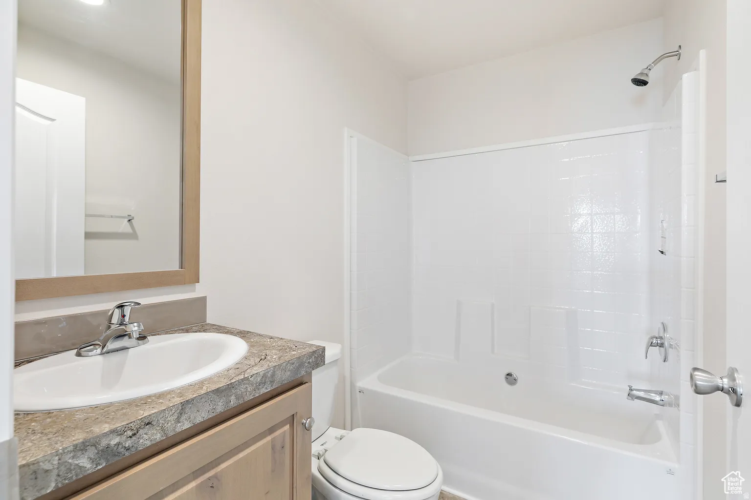 Bathroom featuring a white integrated tub and shower combination with a textured surround