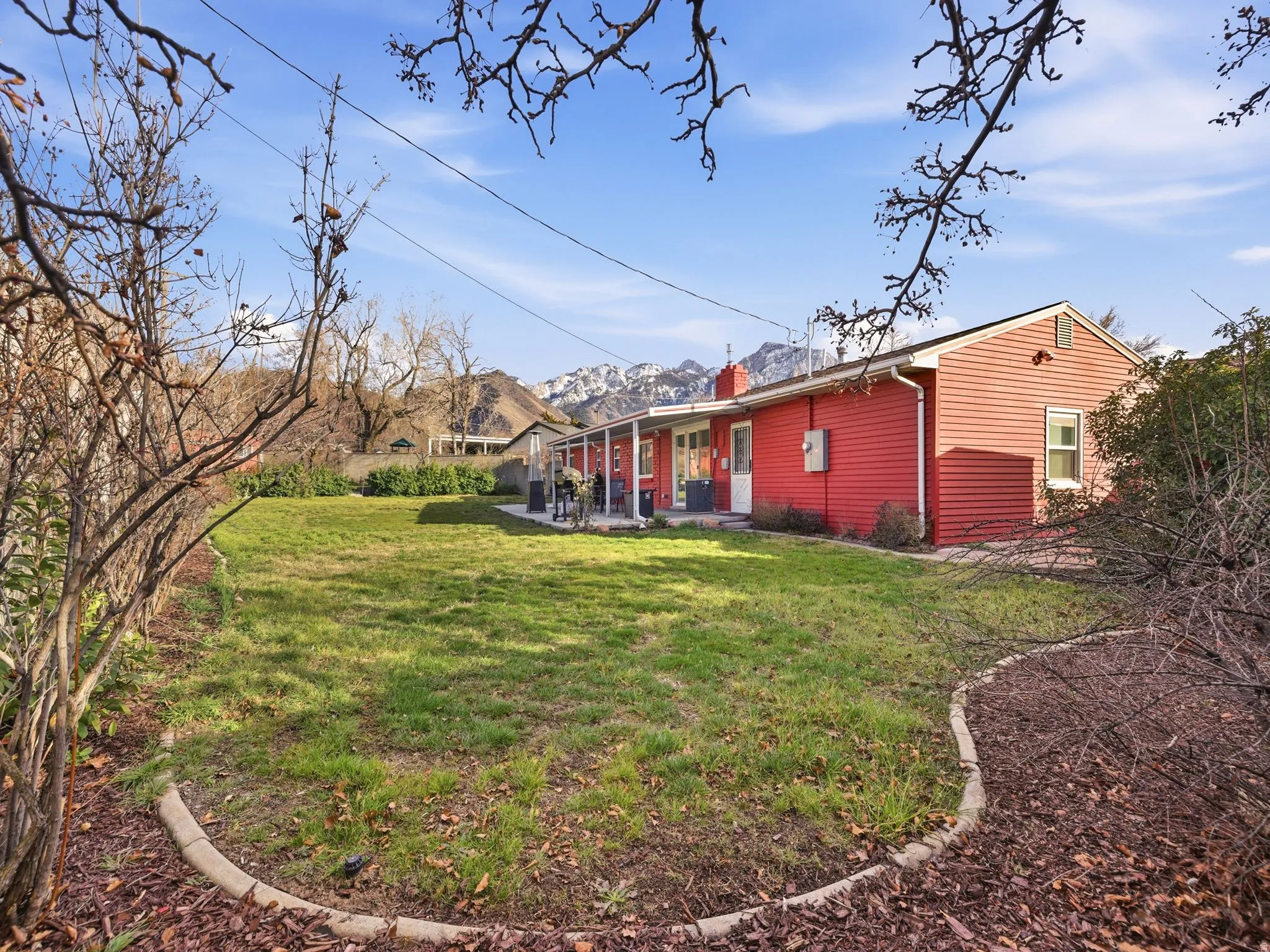 Expansive rear yard featuring a manicured lawn and a curved landscape border