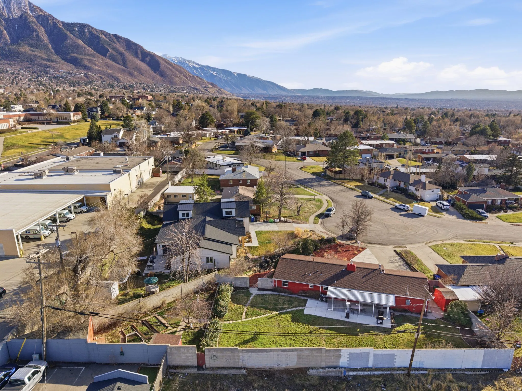Residential neighborhood with an expansive mountain backdrop, featuring single-family homes and mature trees