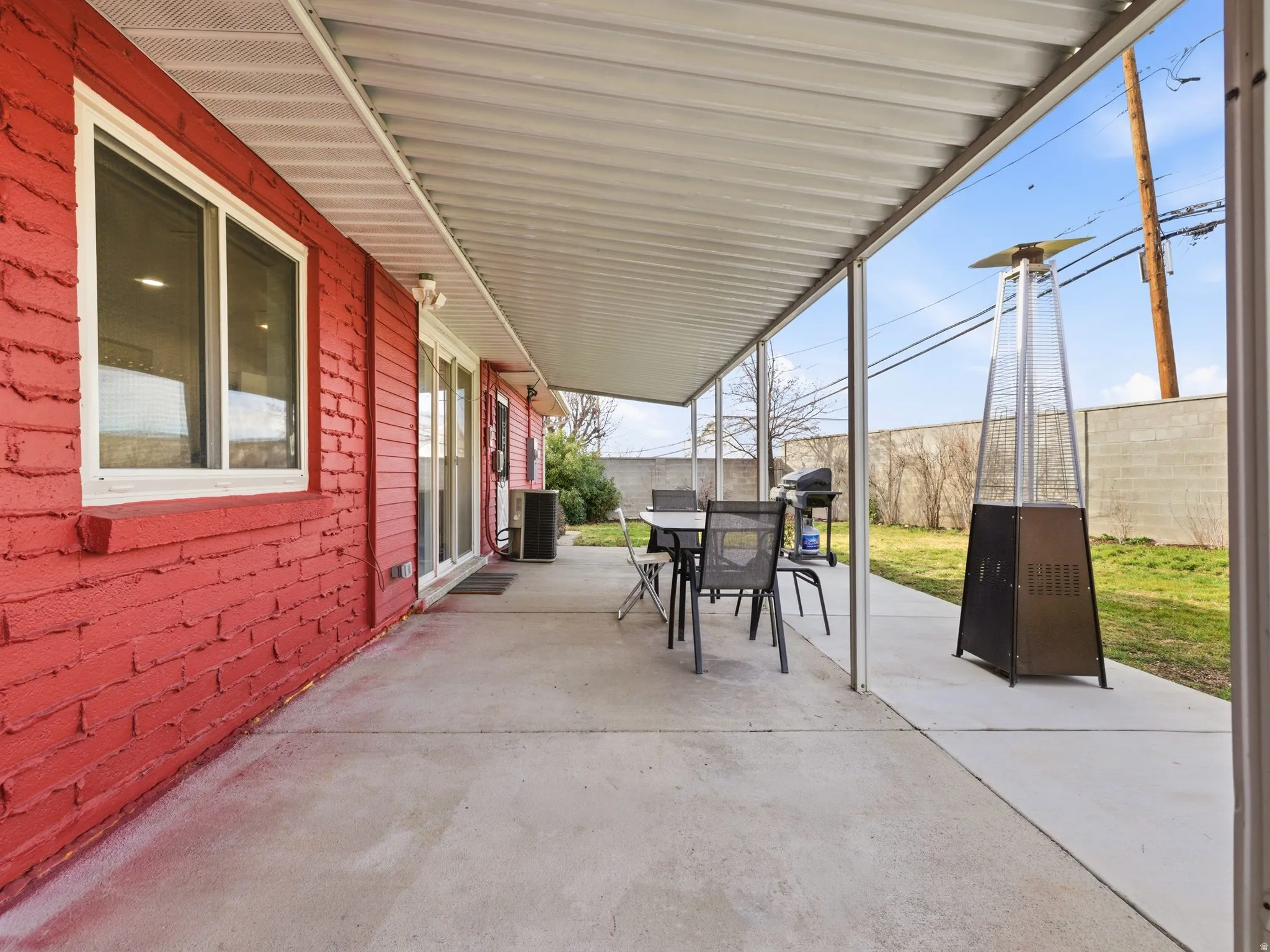 Expansive concrete patio area with a white metal patio cover