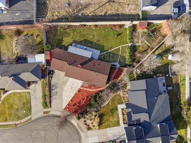 Expansive property featuring a large landscaped front yard, concrete driveway, and a substantial fenced backyard with mature trees