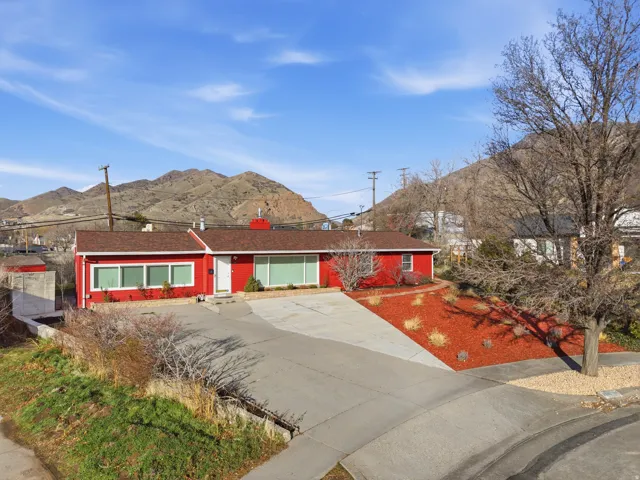 Red-sided ranch-style residence featuring a white front door and trim