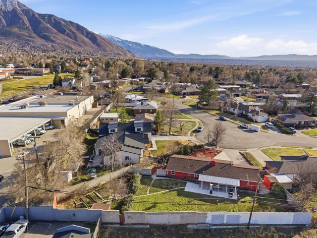 Residential neighborhood with an expansive mountain backdrop, featuring single-family homes and mature trees