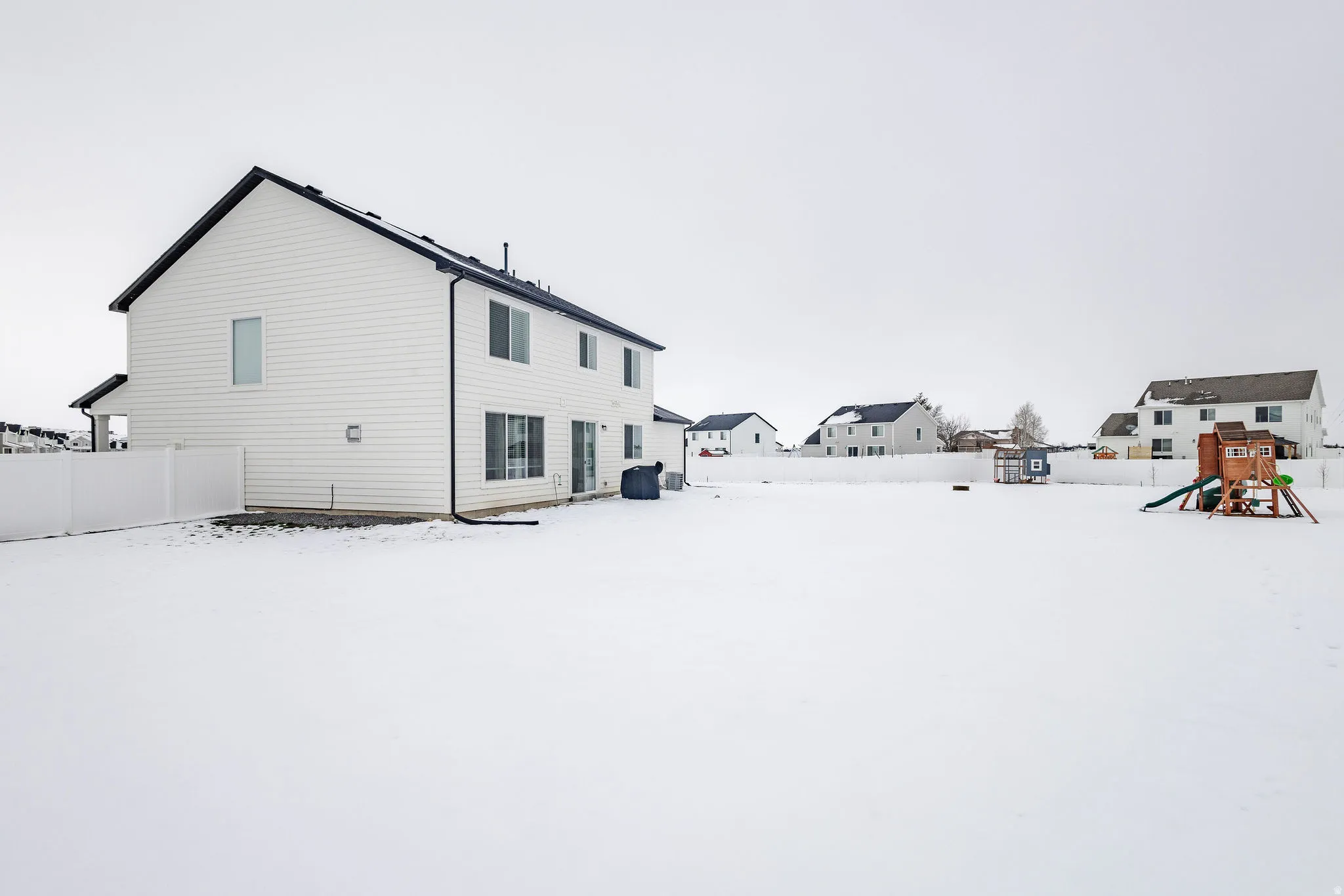 Two-story residence featuring white siding and a dark gabled roofline