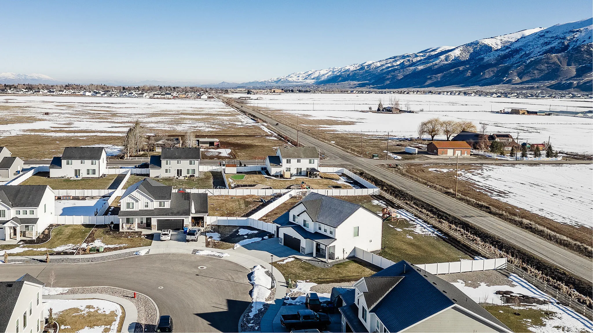 Expansive suburban neighborhood with snow-dusted fields and distant mountains