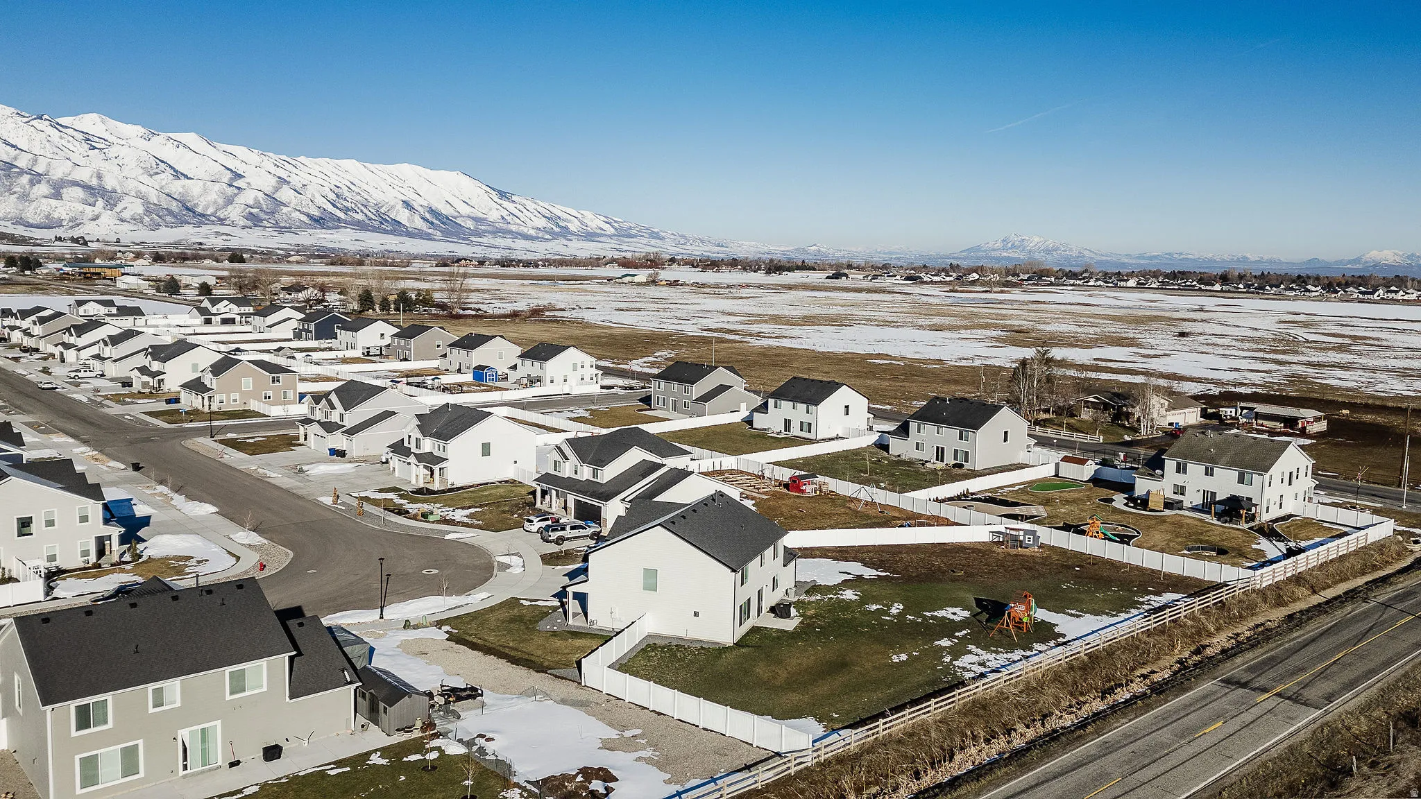 Residential development featuring a street grid, individual properties, and a mountainous backdrop