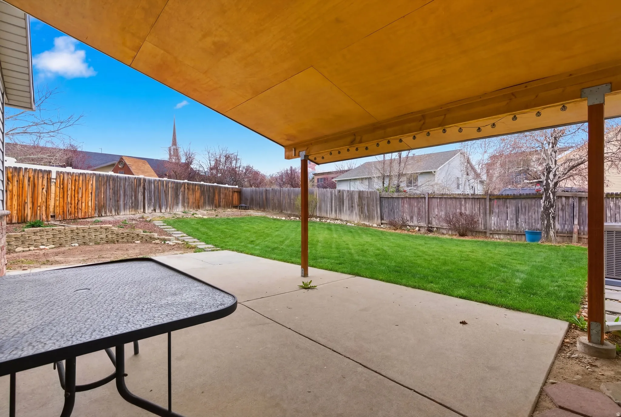 Covered patio featuring string lights and a concrete surface