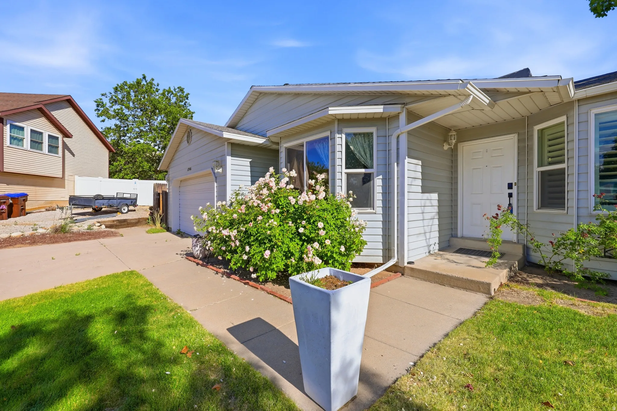 Light gray siding exterior with a white front door and covered entry