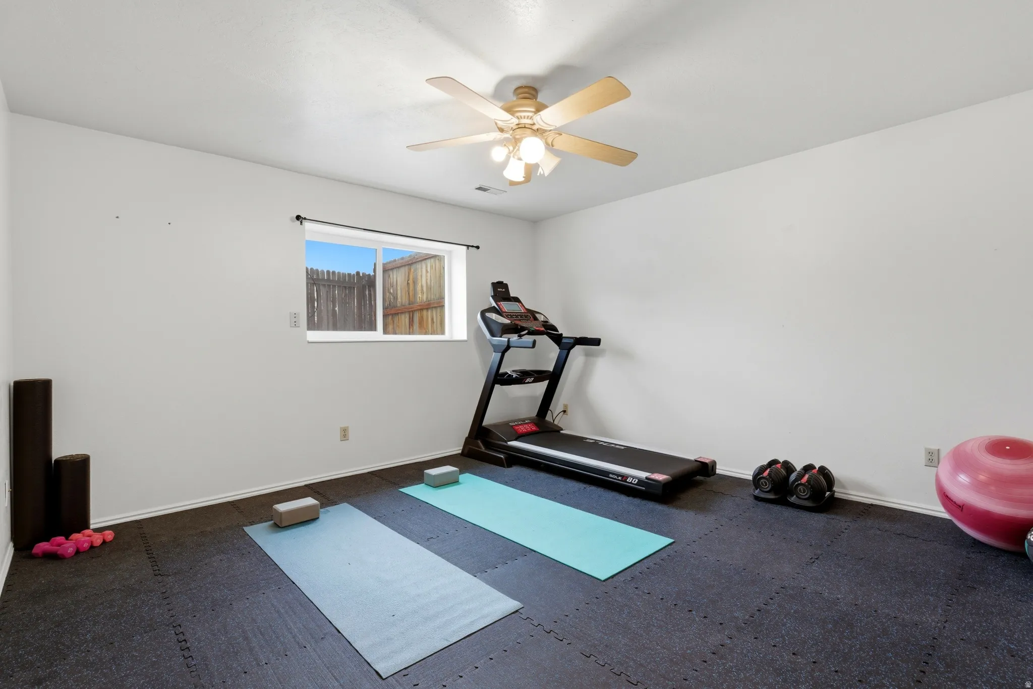 Basement family room, fully carpeted beneath gym mat flooring
