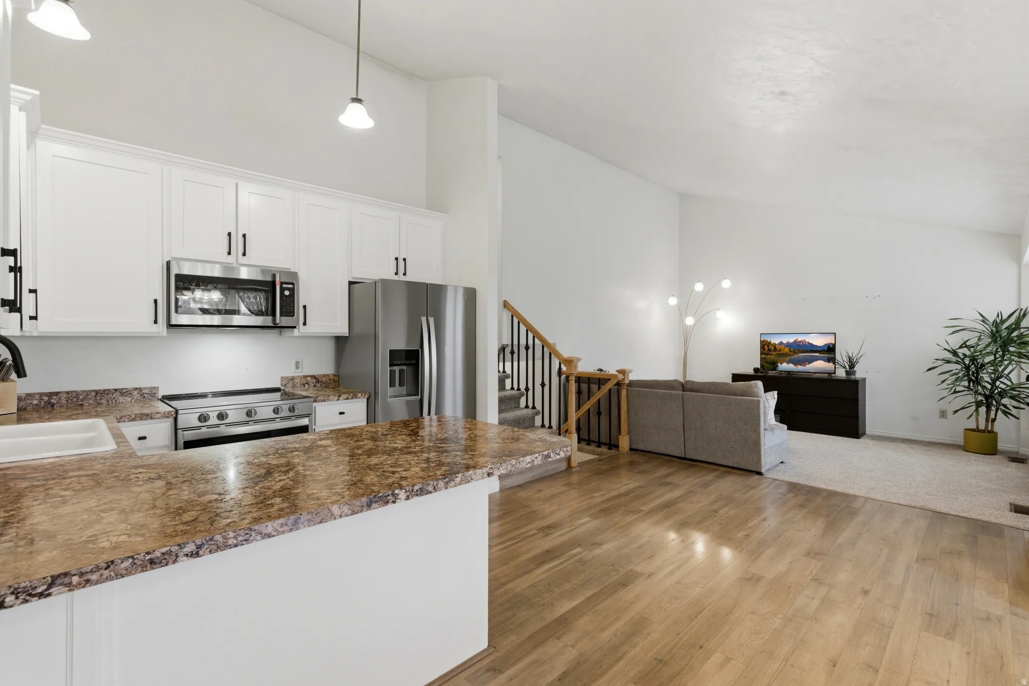 Open-concept living space with wood-finish flooring extending into the kitchen