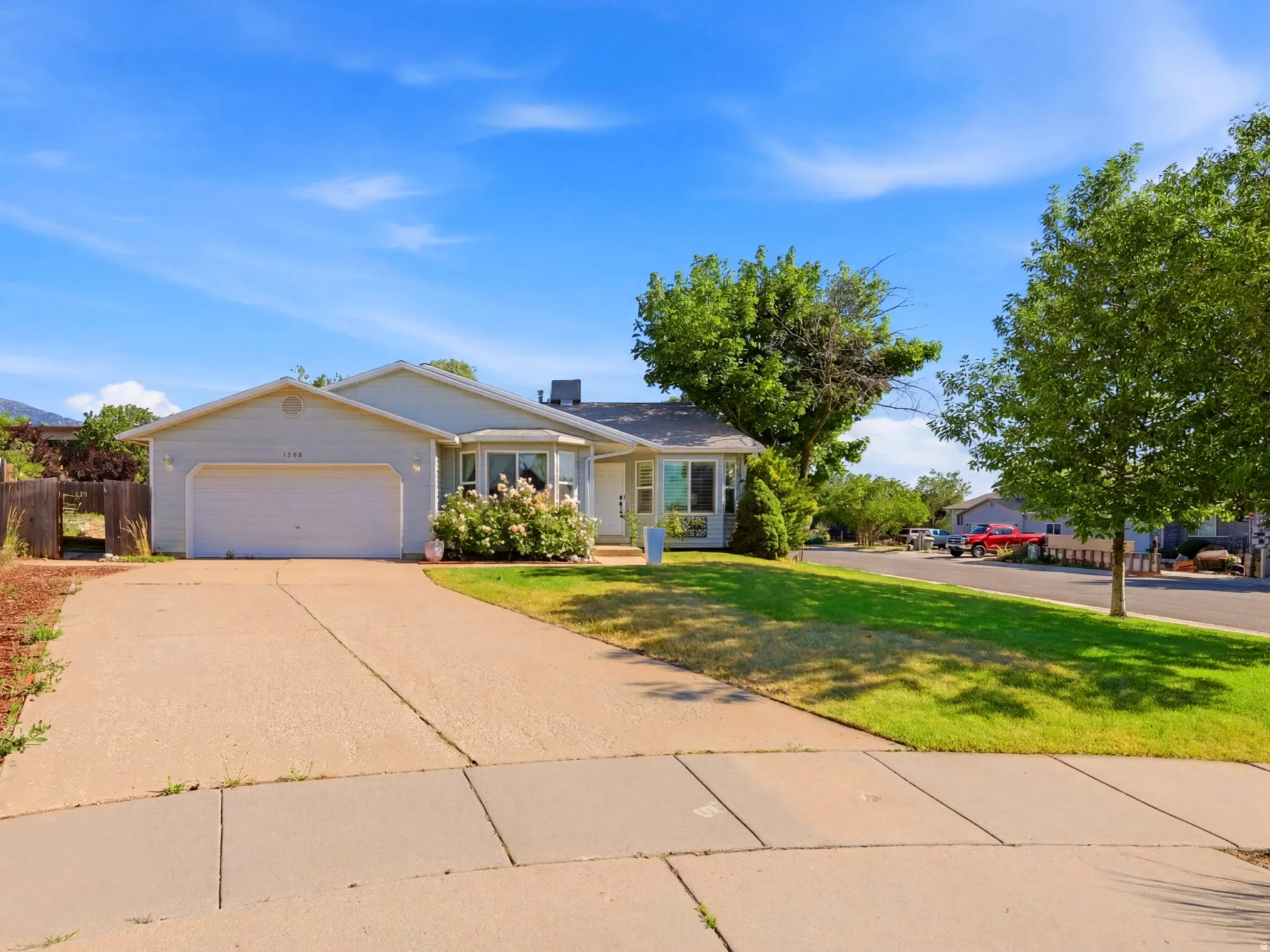 Ranch-style residence featuring a light-colored exterior and an attached two-car garage