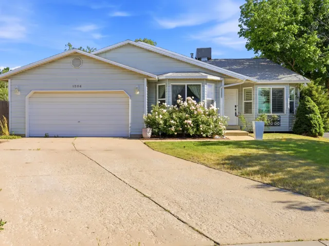 Ranch-style residence featuring light blue siding, a two-car garage, and a concrete driveway