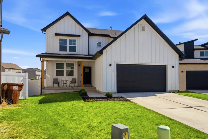 Modern farmhouse exterior with white board and batten siding, black trim, and a prominent gable roofline