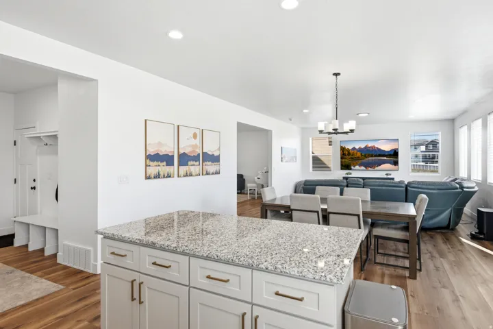 Kitchen island featuring a granite-style countertop and white cabinetry with brass hardware