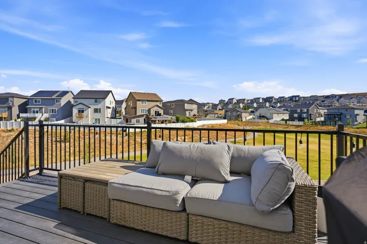 Expansive outdoor deck featuring composite decking, black metal railings, and an open sky