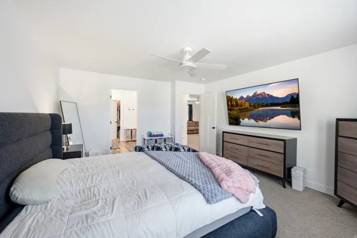 Spacious bedroom featuring neutral carpeting and white walls