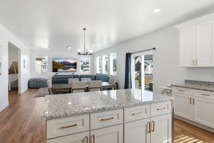 Kitchen island with a light-toned countertop and white cabinetry featuring gold-toned hardware