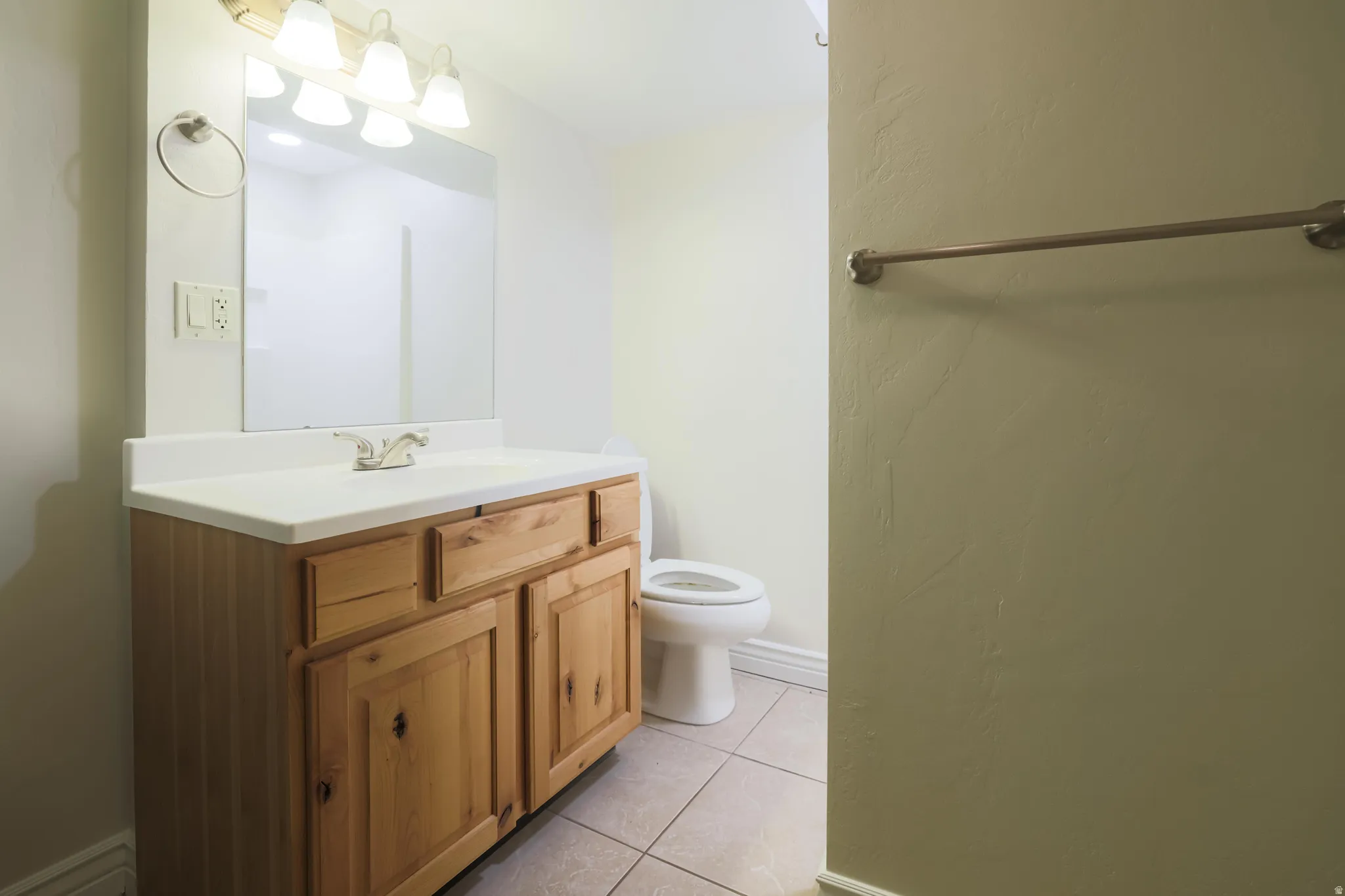 Wood-finish vanity with a white countertop and integrated sink