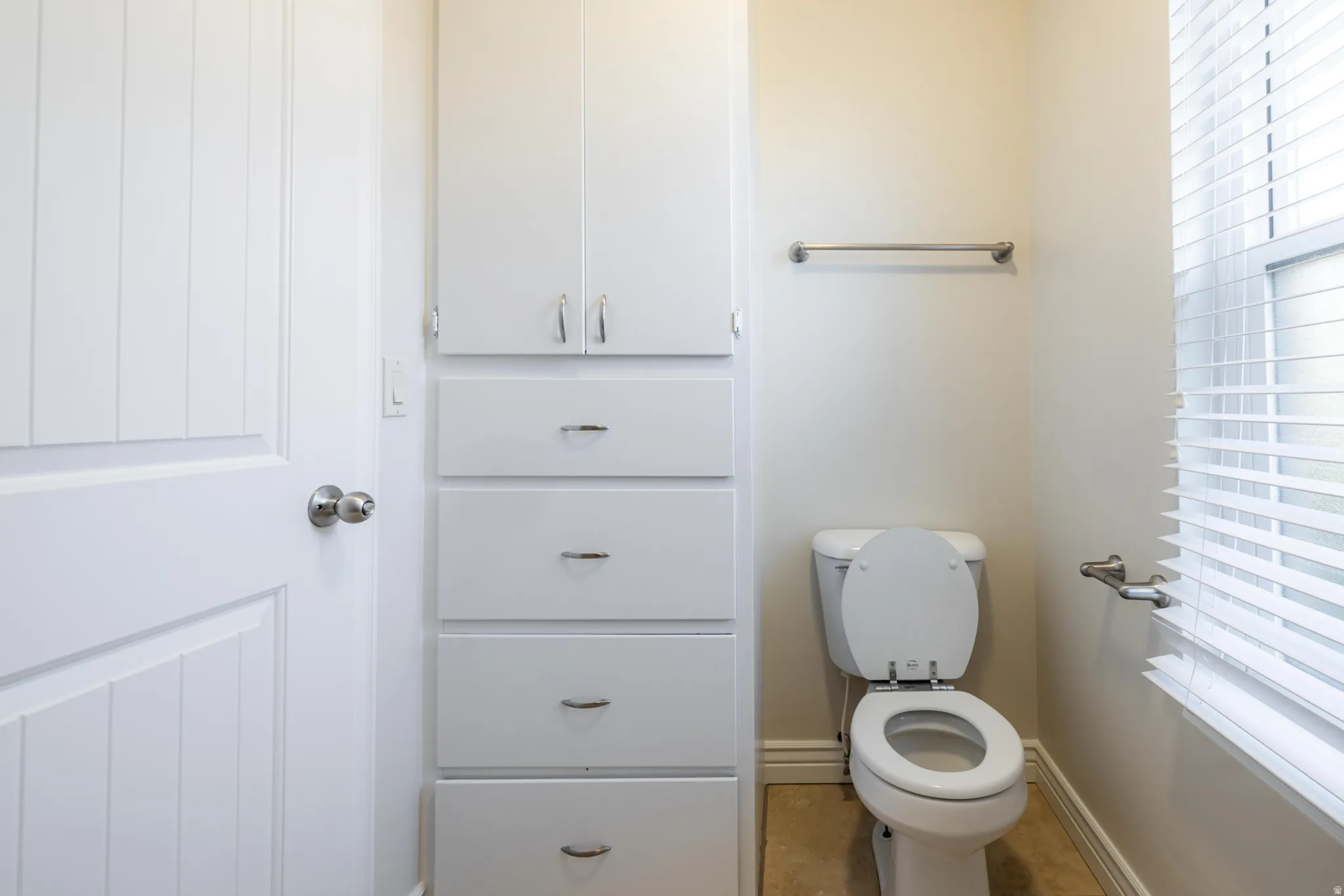 White storage cabinetry with polished chrome hardware