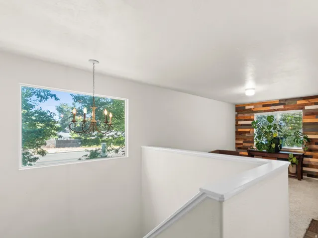 Bonus room featuring warm wood accent walls perfect flex space for a home office, playroom, gym, hobby room or a potential third bedroom