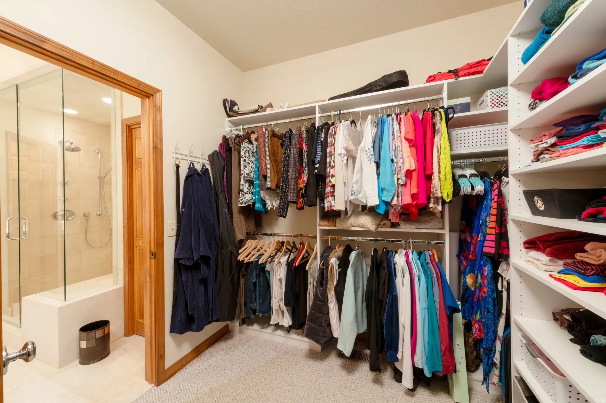Custom closet system featuring multiple hanging rods and extensive shelving