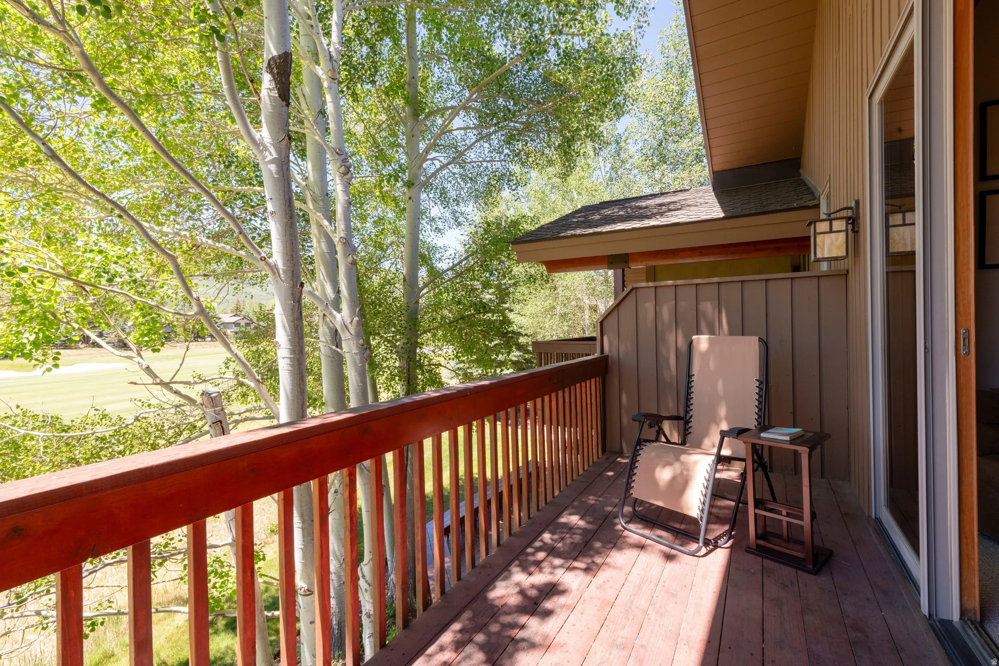 Private balcony featuring wood-finish decking and railing