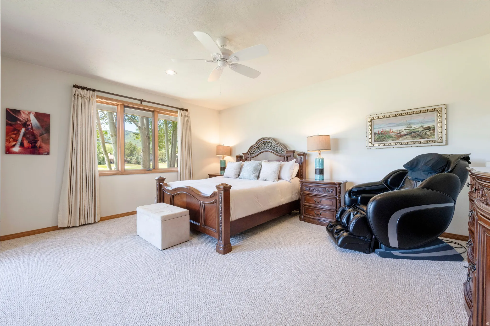 Carpeted bedroom featuring a ceiling fan, recessed lighting, and a large window with wood trim