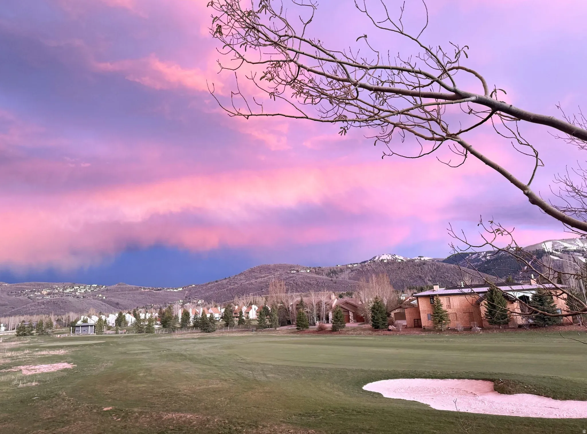 Expansive green golf course with a sand trap