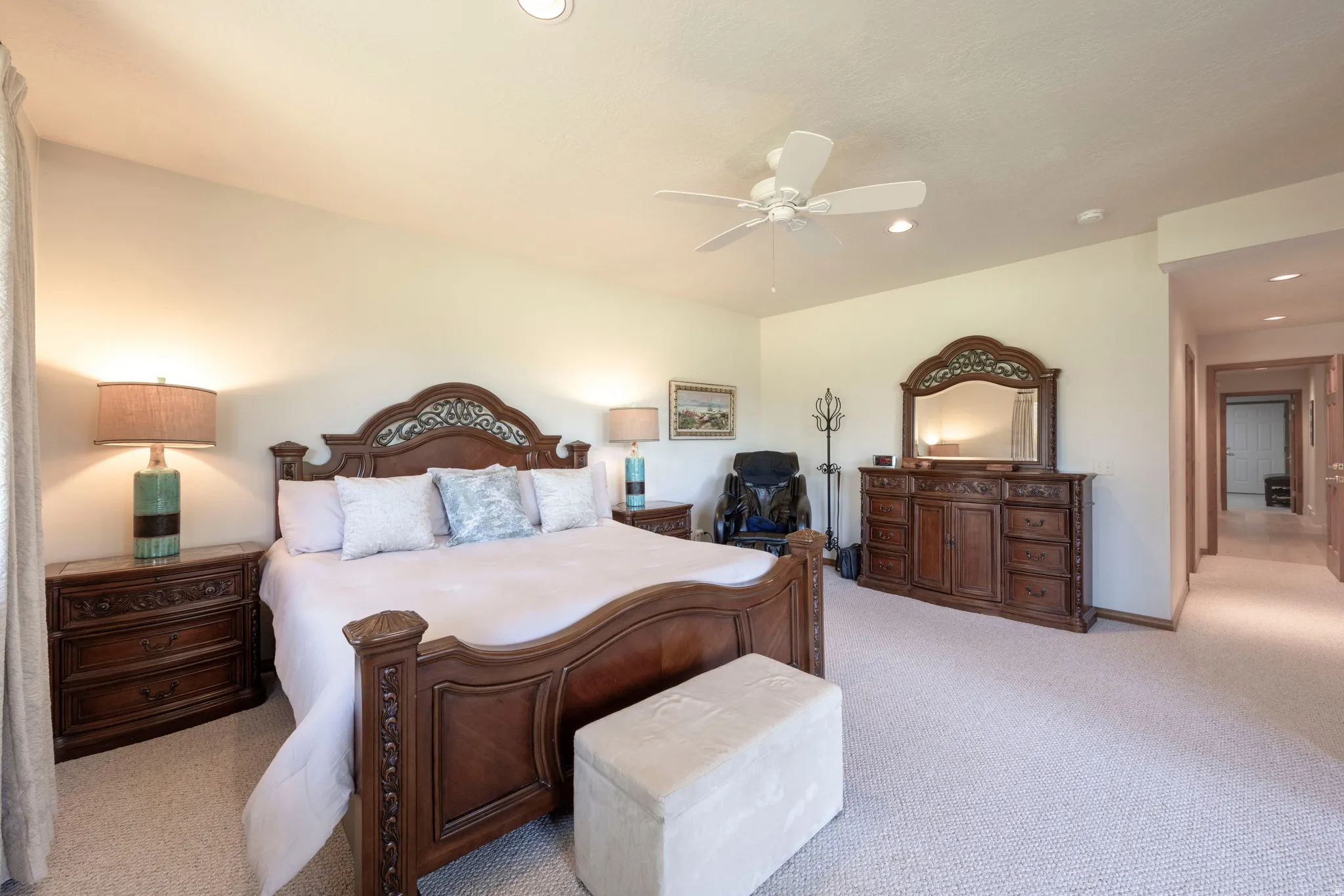 Carpeted interior space featuring a ceiling fan, recessed lighting, and an adjacent hallway