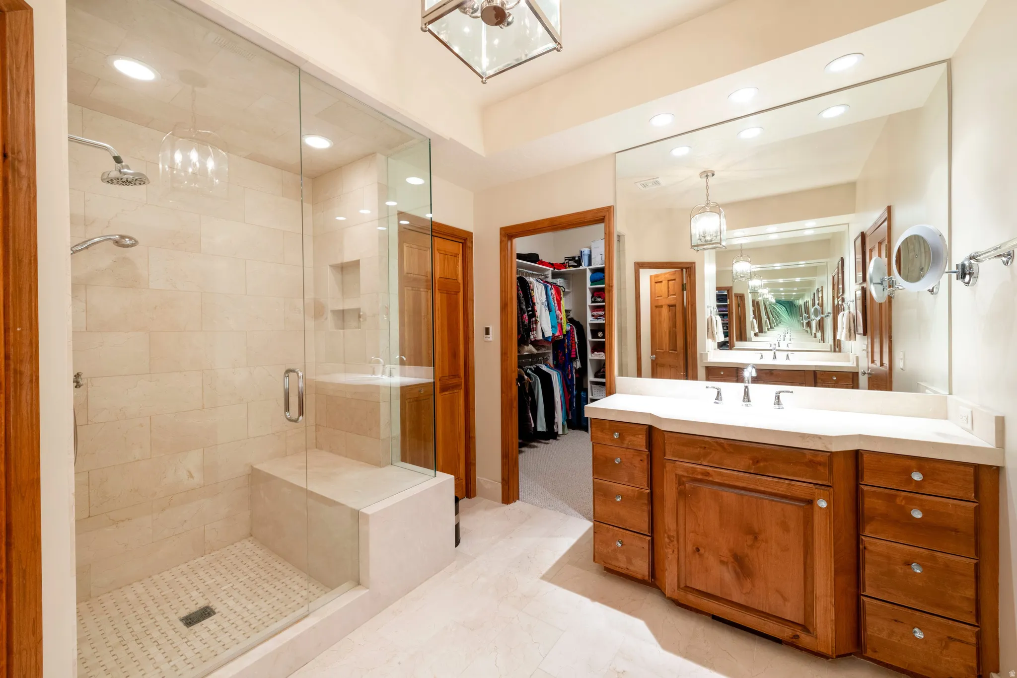 Spacious bathroom featuring a glass-enclosed shower with a built-in bench and dual shower heads