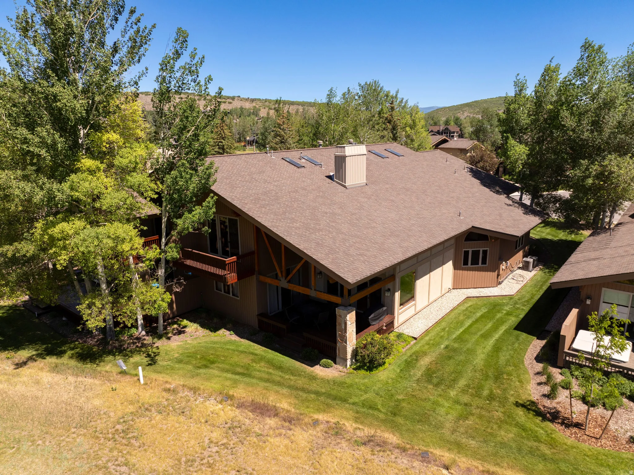 Contemporary residence with a multi-level roofline, skylights, and a stone chimney