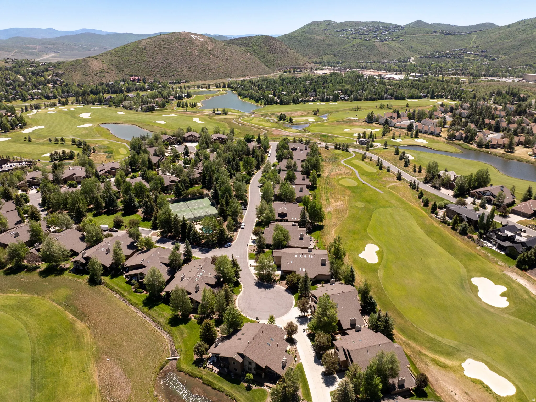 Expansive aerial view showcasing a residential community amidst a golf course