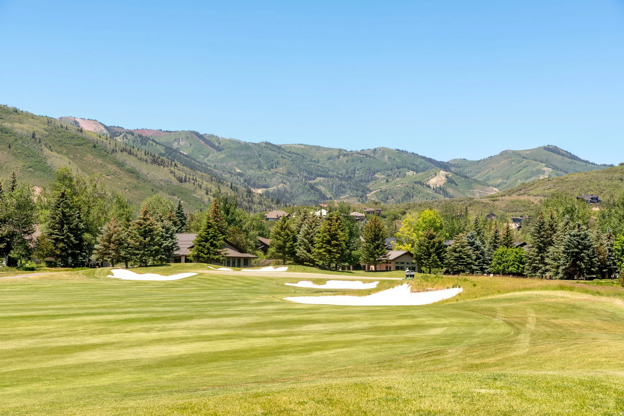 Expansive golf course fairway featuring sand traps and distant homes