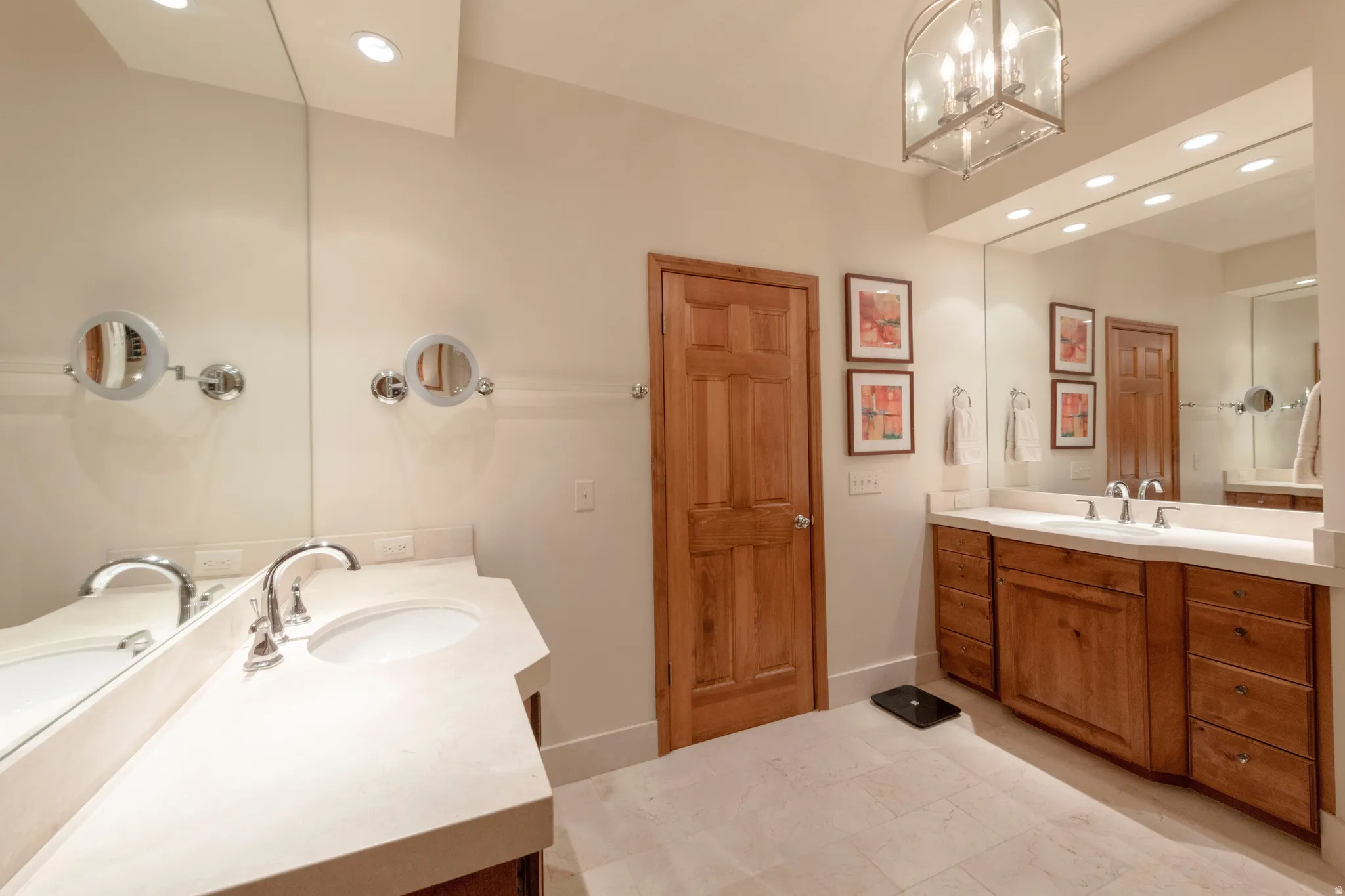 Bathroom featuring a double vanity with light-toned countertops, integrated sinks, and polished chrome fixtures
