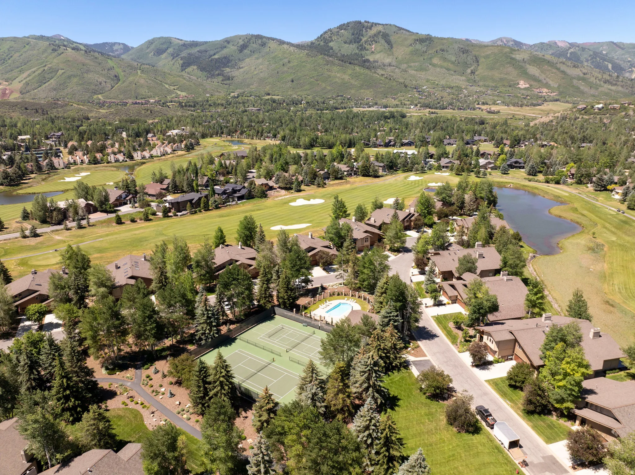 Expansive aerial perspective showcasing a residential community amidst natural landscaping and distant mountains