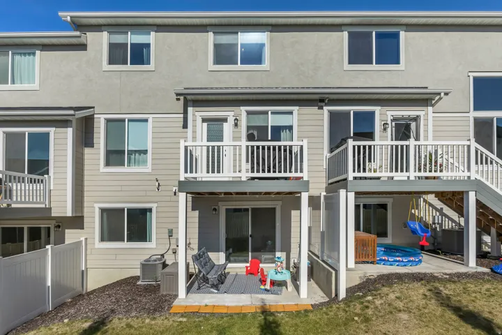 Multi-level rear exterior featuring a ground-level patio and upper-level deck