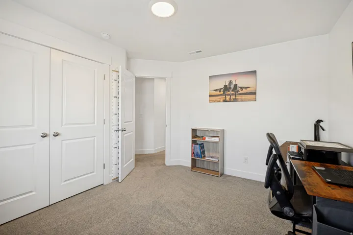 Carpeted room featuring white walls, white trim, and a flush-mount ceiling light