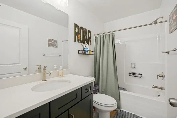 Bathroom featuring a dark wood-finish vanity with a light countertop, an undermount sink, and brushed nickel fixtures
