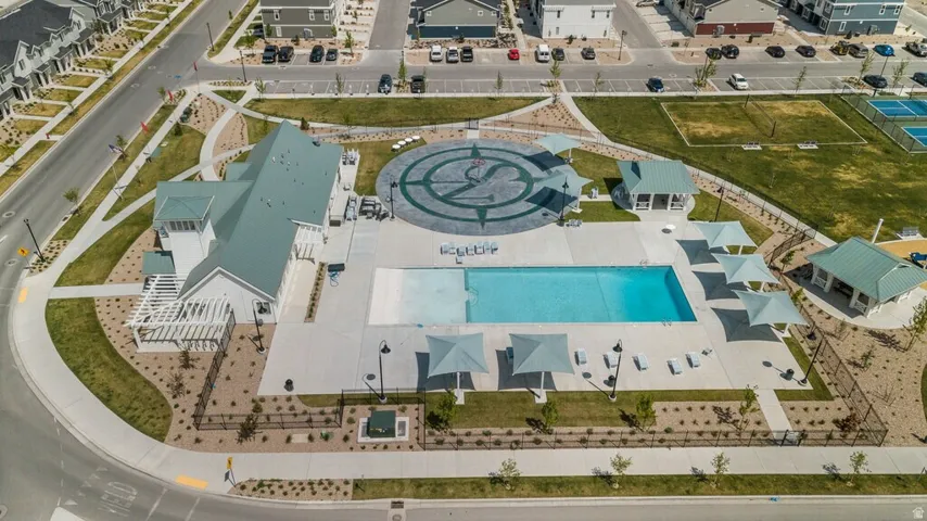 Recreational facility featuring a central swimming pool, multiple shade structures, and surrounding lounge seating