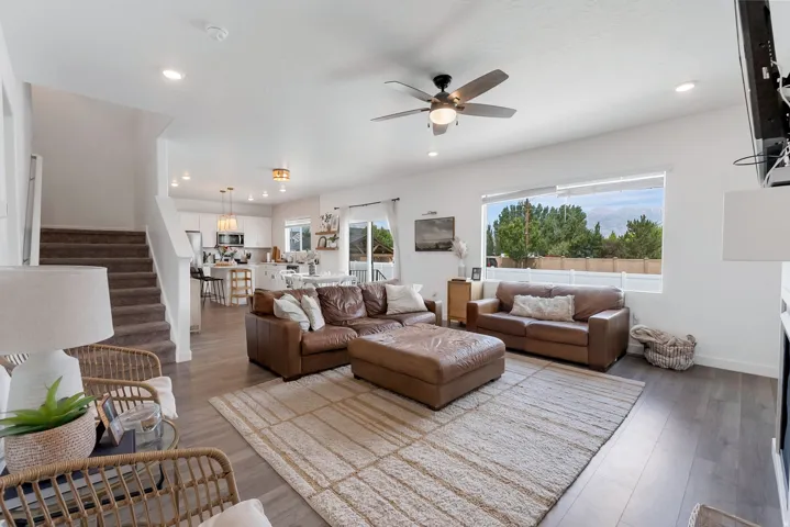Open-concept living space featuring wood-finish flooring, recessed lighting, and a ceiling fan