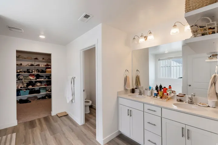 Bathroom featuring a dual vanity with white cabinetry, light-toned countertops, and dual undermount sinks