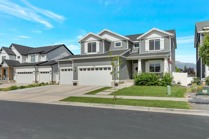 Contemporary two-story residence featuring grey siding with white trim accents and a dark roof