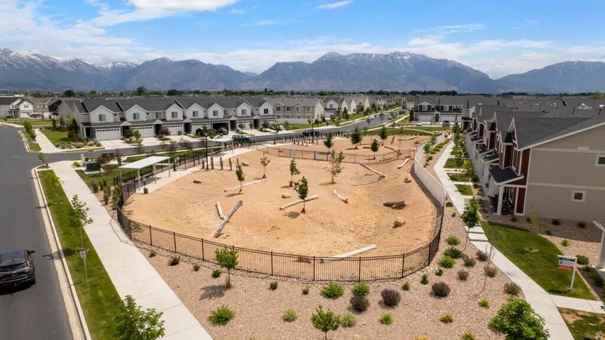 Central community dog park with a fenced perimeter and integrated walking paths