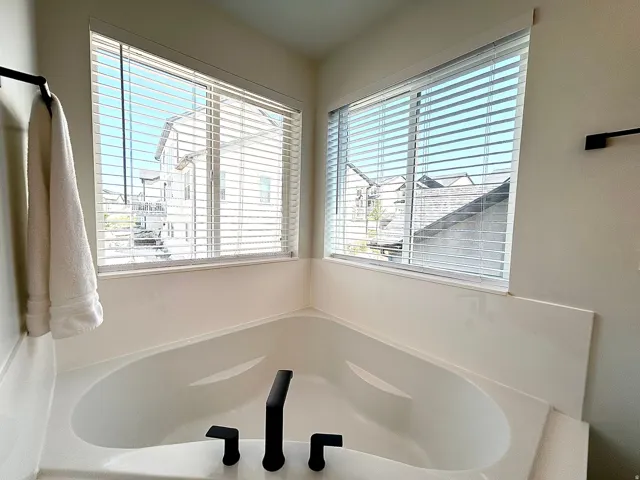 Corner soaking tub with a matte black faucet and fixtures
