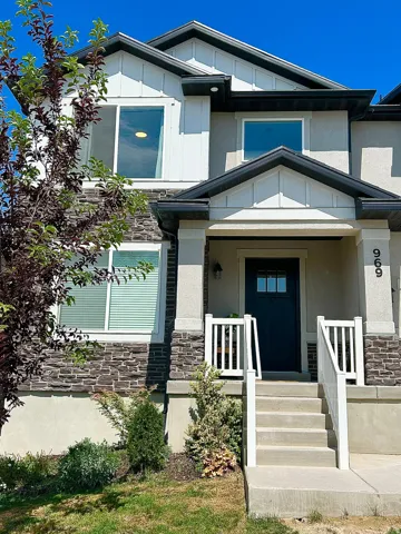 Multi-level facade featuring stone accents, vertical white siding, and stucco finishes