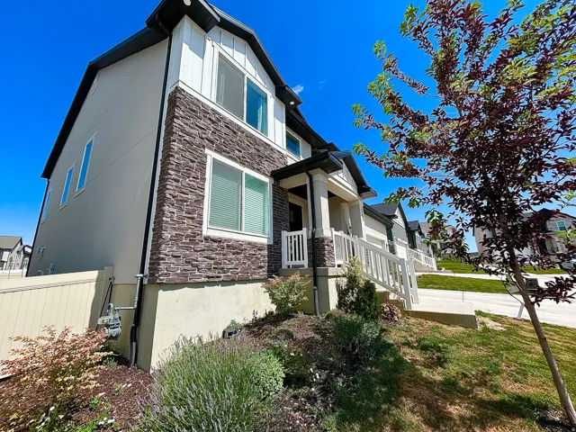 Two-story exterior featuring stone veneer and vertical white siding accents