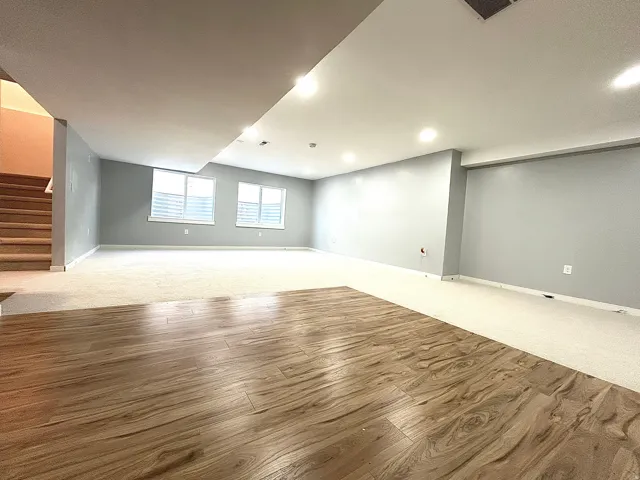Spacious lower level featuring wood-finish flooring and light-toned carpeting